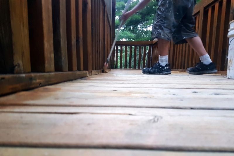 a man with a broom cleaning the decking floor