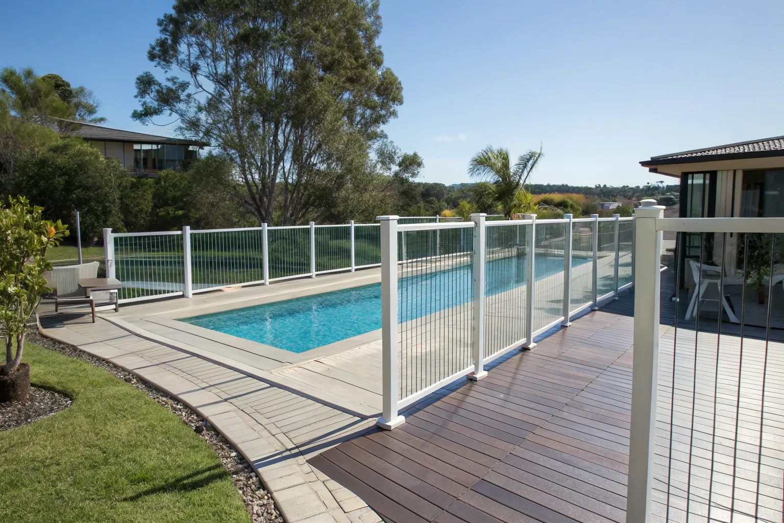Pool deck meeting a fence barrier with safe spacing